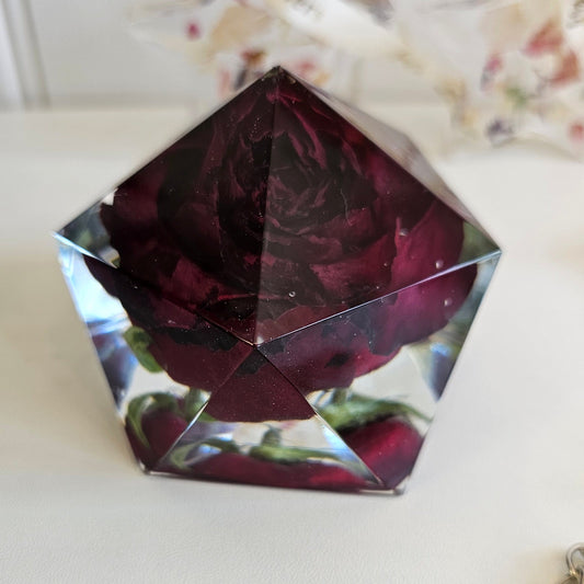 resin flower preservation pyramid with a rose inside on a white surface