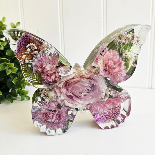 preserved funeral flowers in a butterfly shape resin ornament. a memorial keepsake