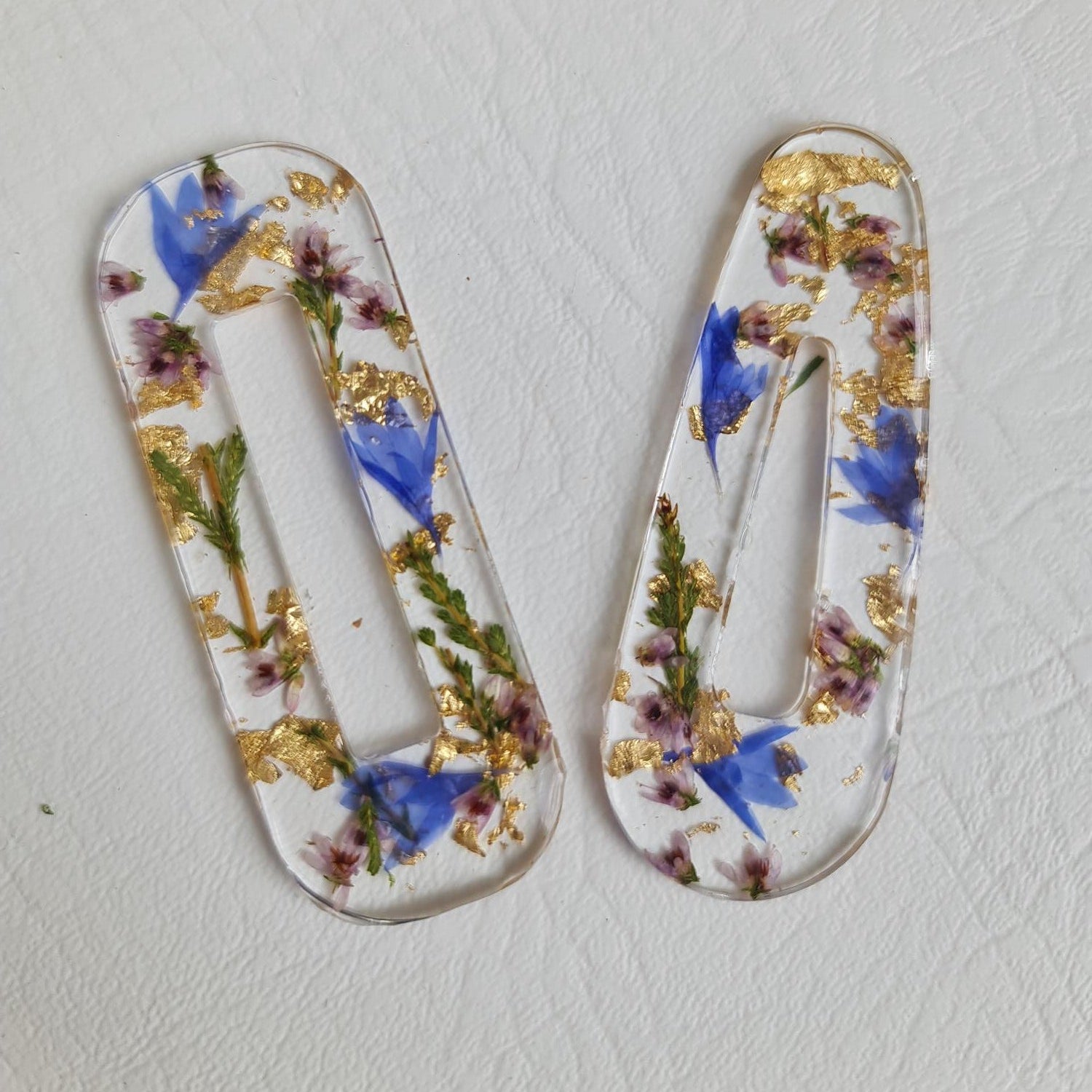 Two decorative hair clips with floral design on a light gray background