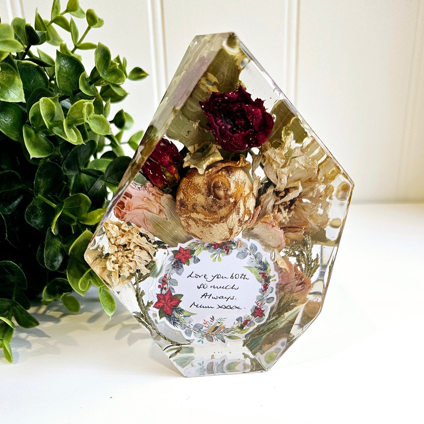 funeral flowers preserved in a clear resin gem shape ornament 