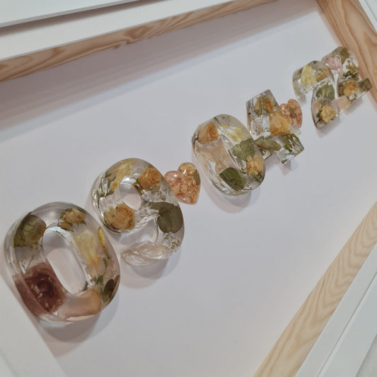 clear resin with wedding flowers preserved in number shapes framed 