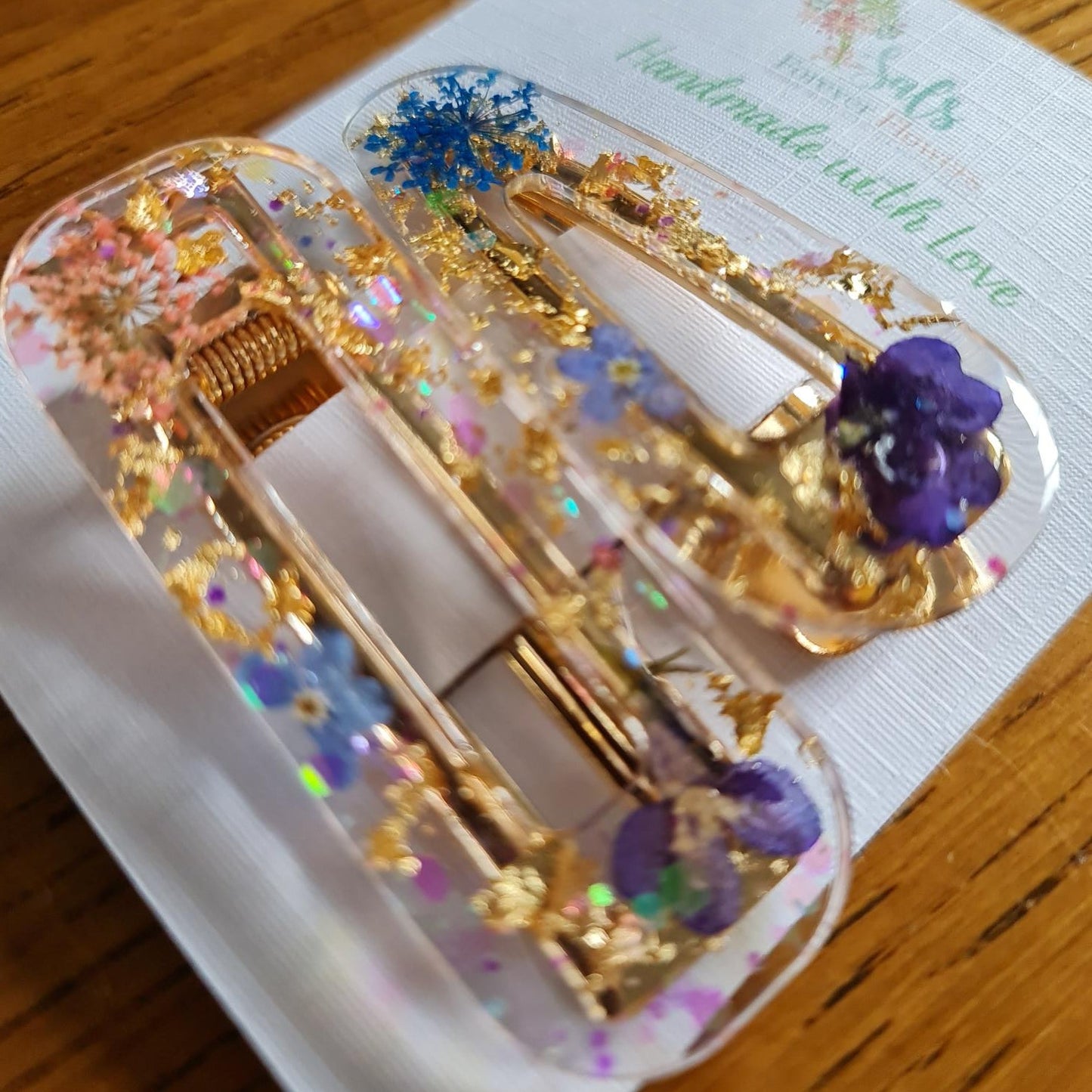 Decorative box with gold accents and purple flowers on a wooden surface